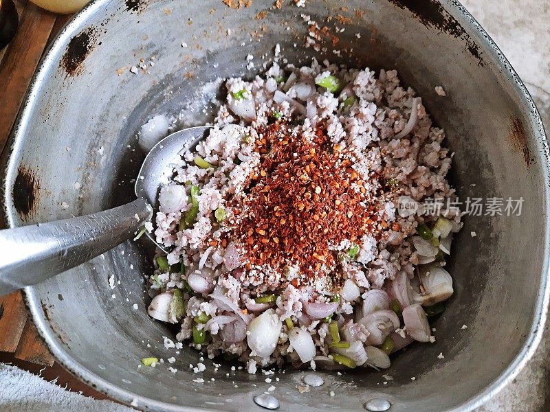 烹饪鸡肉辣沙拉(Larb kai) -泰国食物的准备。